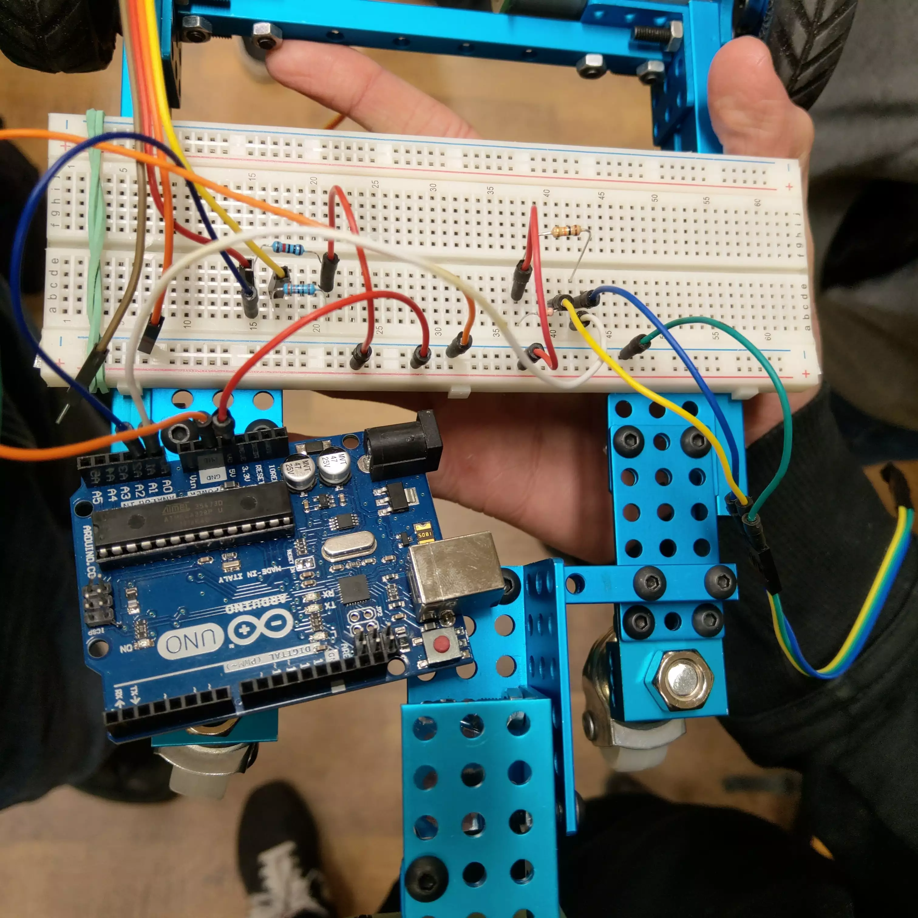 Arduino Uno board connected with breadboard using lots of jumpers. Breadboard connects with line sensors and has resistors pinned